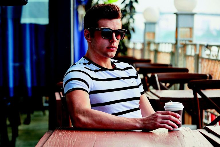 Man in blauwe polo en beige korte broek als perfecte zomeroutfit voor heren